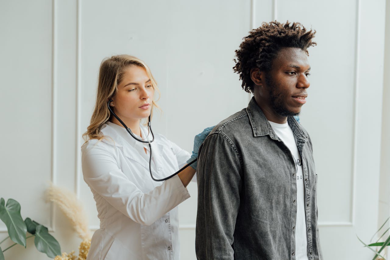Doctor conducting check-up on patient with stethoscope indoors.